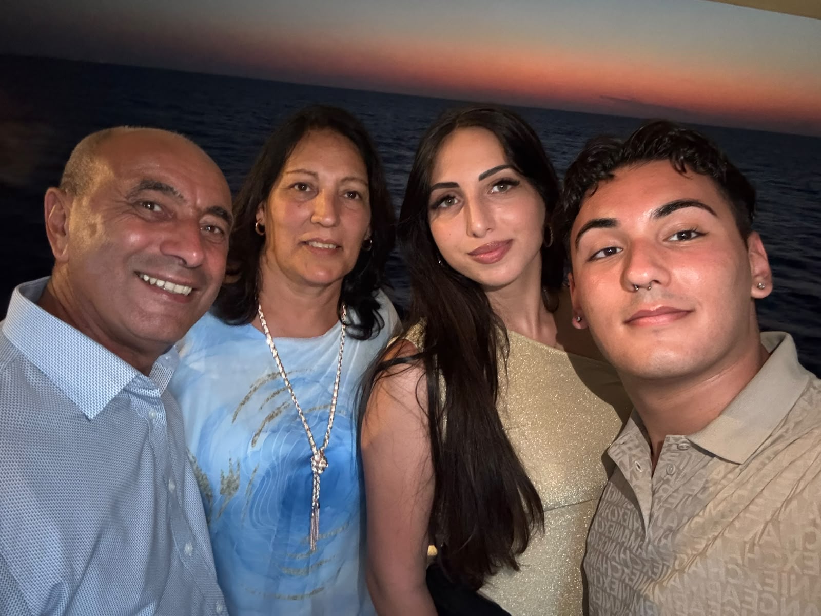 The family together at dinner by the sea at sunset
